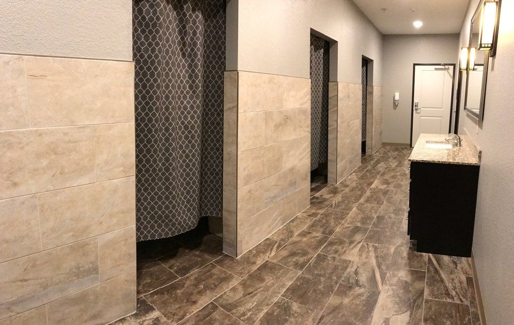 A modern bathroom interior featuring tiled floors and privacy shower curtains.
