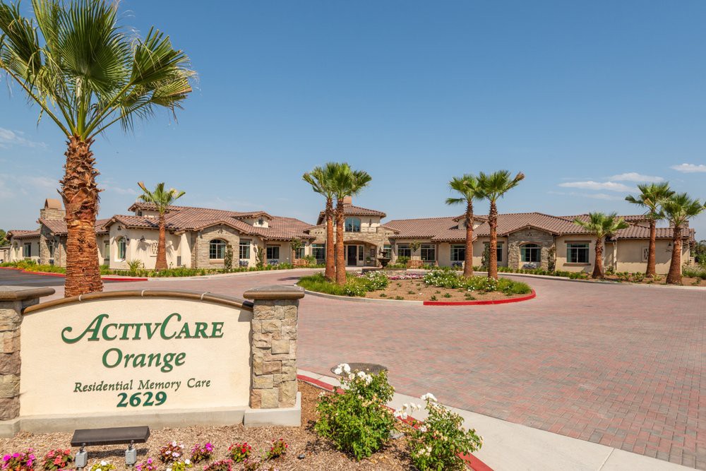 A well-maintained building entrance with palm trees and clear signage.