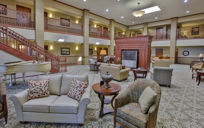 Spacious hotel lobby with comfortable seating and a central fireplace.