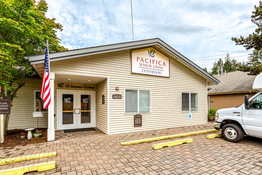 A single-story building with an entrance, displaying a sign and an American flag outside.