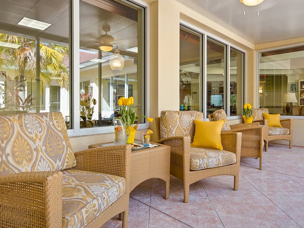A cozy outdoor patio with wicker chairs and yellow-themed decor.