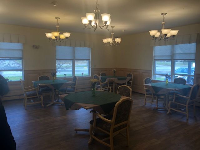 A well-lit dining room with several tables and chairs arranged neatly.