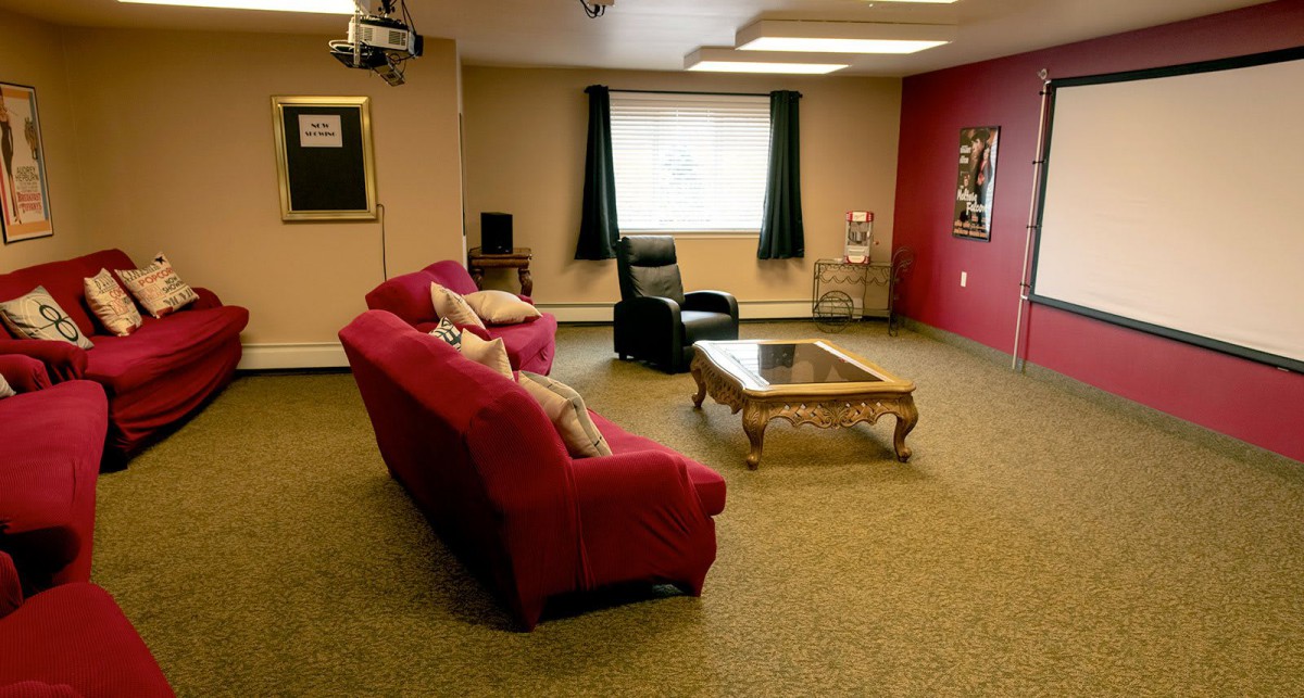 Cozy living room with a red sofa, armchair, and a glass coffee table.