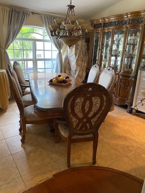 A cozy dining room featuring a wooden table set with chairs and a decorative china cabinet.