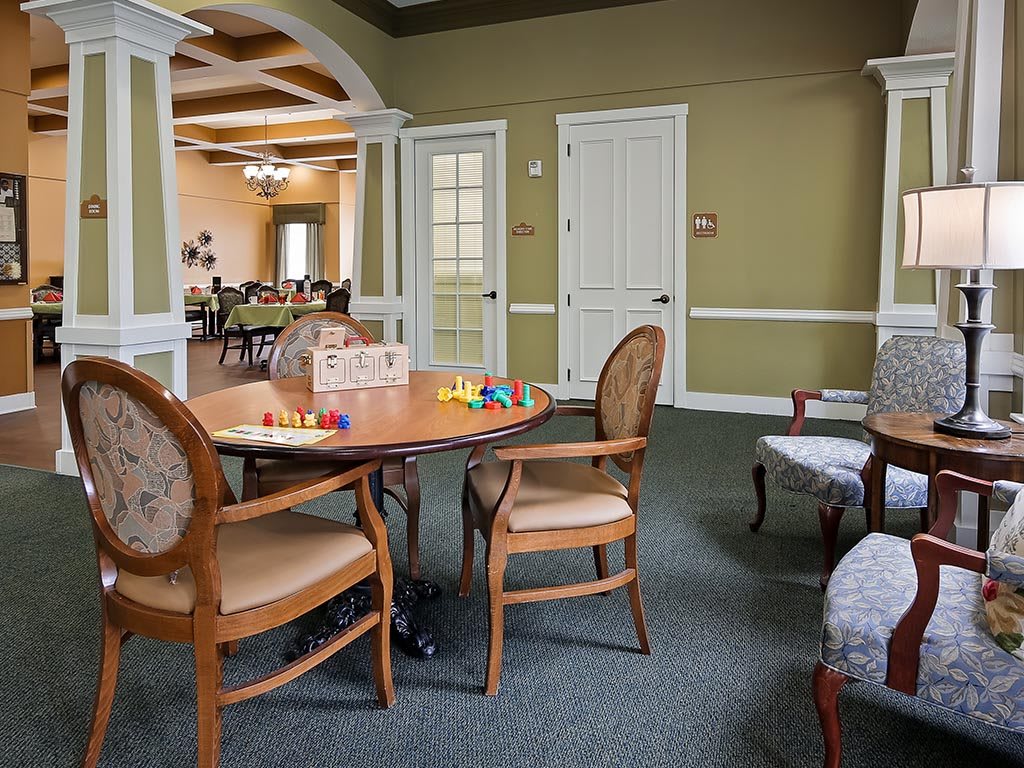A cozy room with a wooden table and chairs, featuring a board game setup.