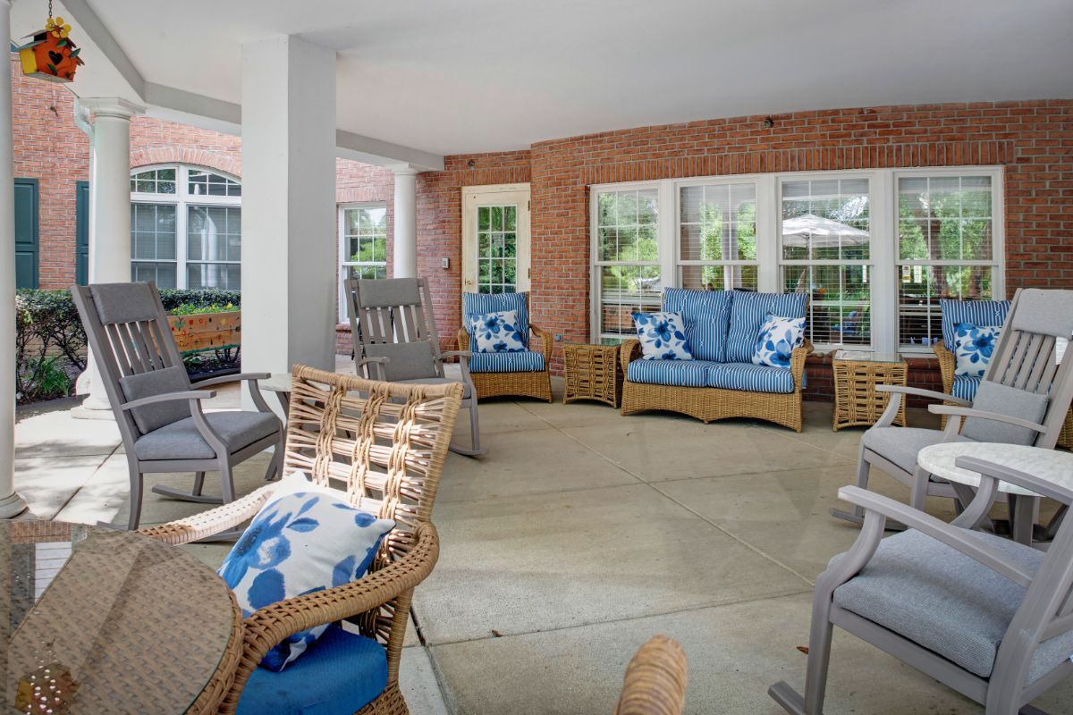 A cozy outdoor patio area with wicker furniture and blue cushions.