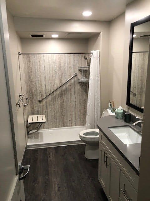 A modern and clean bathroom with a shower area, toilet, and sink.