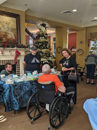 A festive gathering at a senior living community during the holiday season, where residents and visitors engage in warm conversations.