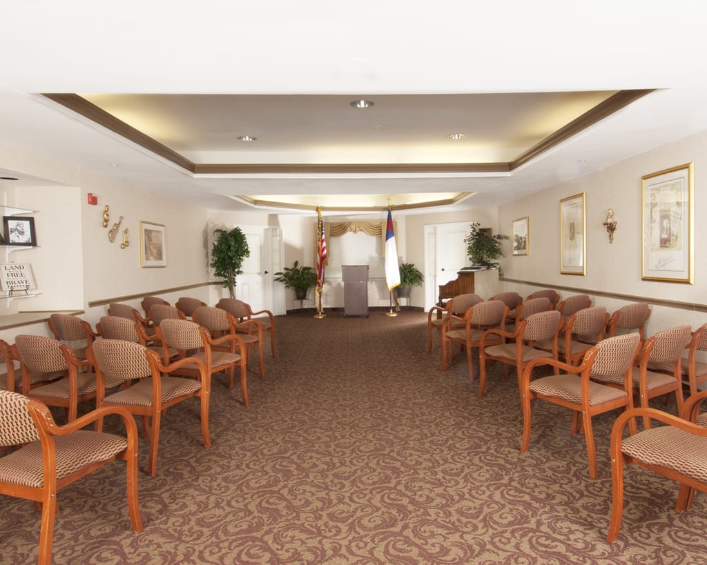 An empty indoor ceremony space with arranged chairs and decorative elements.