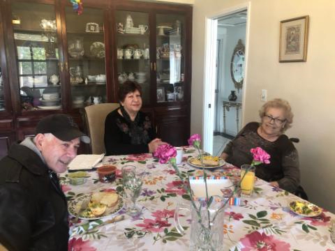 A family gathering around a dining table with floral decorations.