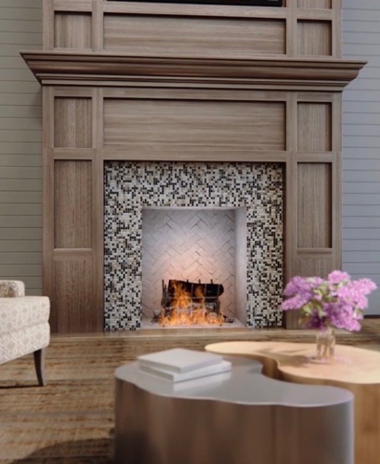 A cozy living room featuring a stylish wood-paneled fireplace with floral tile accents and modern furnishings.