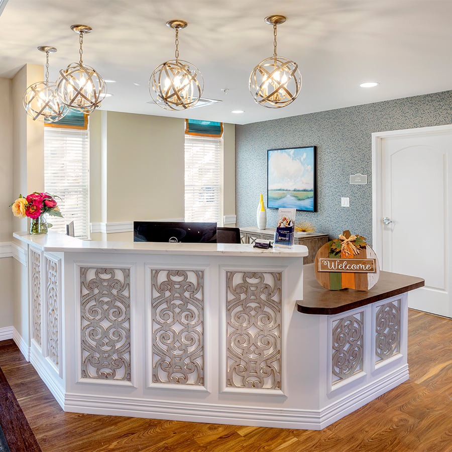 A modern and elegantly designed reception area with decorative lighting and floral arrangements.