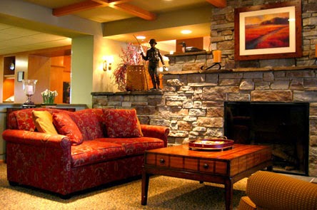 A cozy living room featuring a comfortable sofa, a rustic stone wall, and warm lighting.