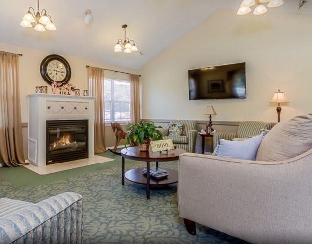 A cozy living room featuring a fireplace, sofa, and television.