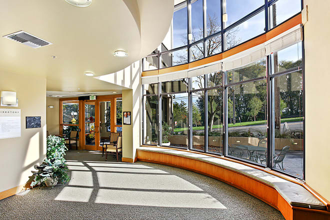 A well-lit modern interior space with large curved windows and a spacious lobby area.