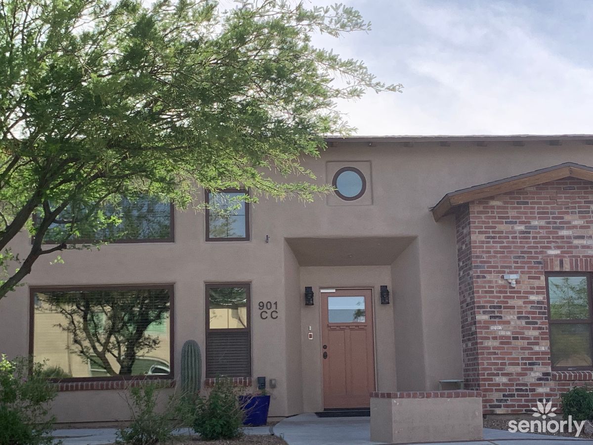 A modern residential house with a brick facade and landscaped front yard.