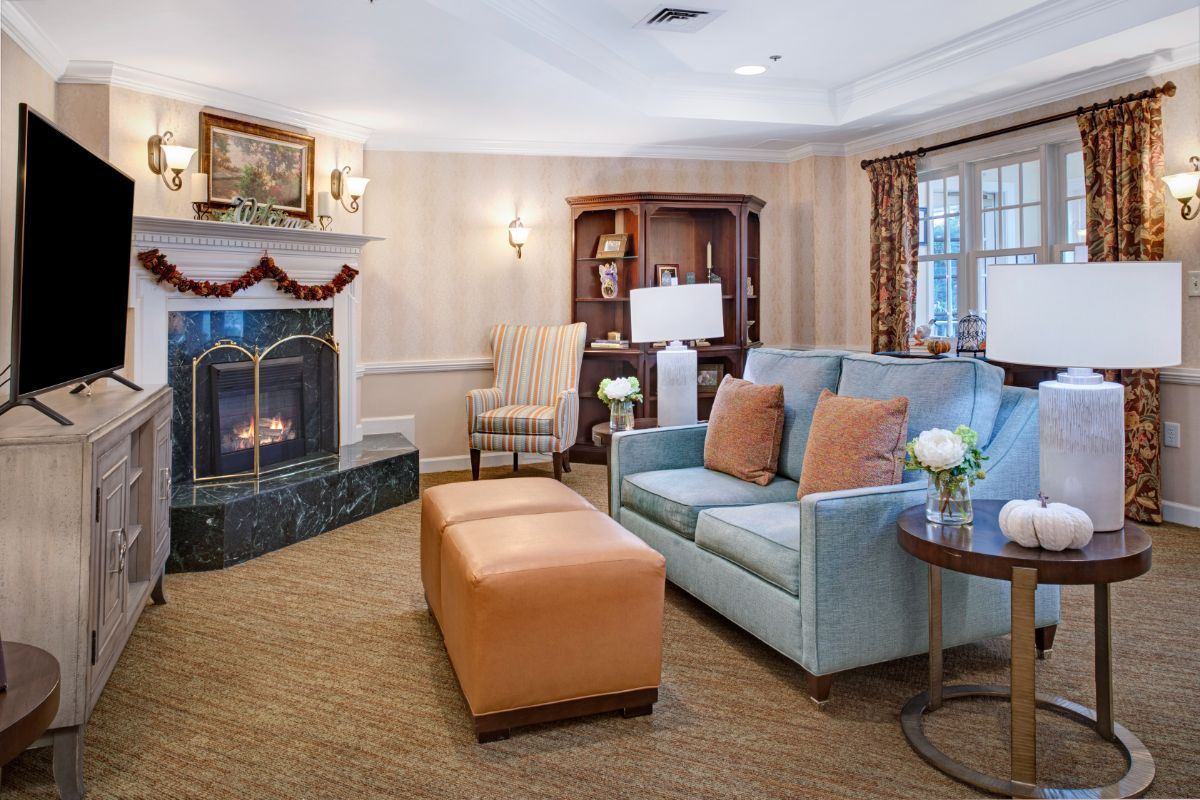 A cozy living room with a comfortable sofa, armchair, and a fireplace, creating a warm and inviting atmosphere.