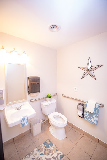 A clean and modern bathroom featuring a toilet, sink, and decorative elements.