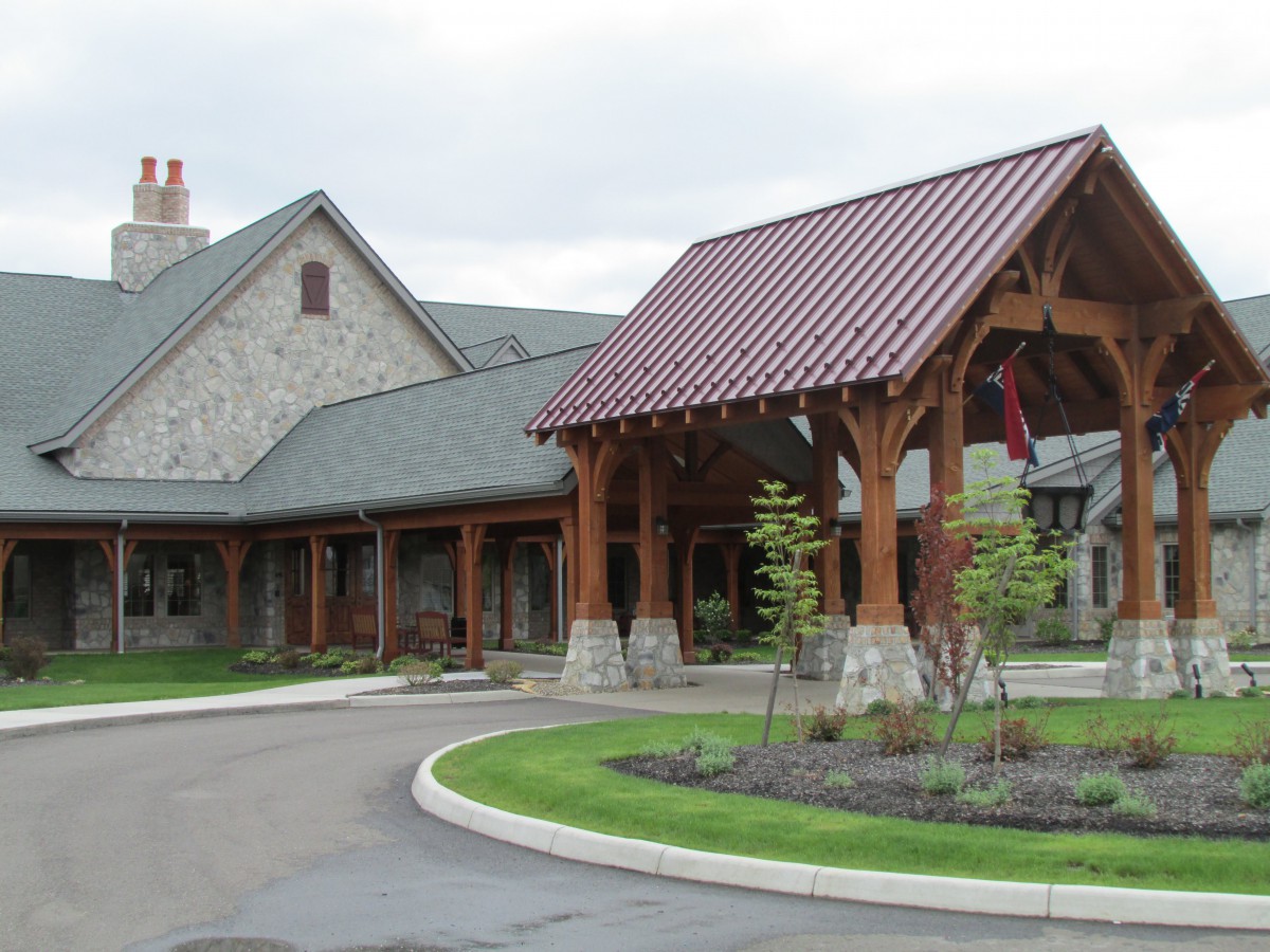 A picturesque building with a wooden entrance and landscaped surroundings.