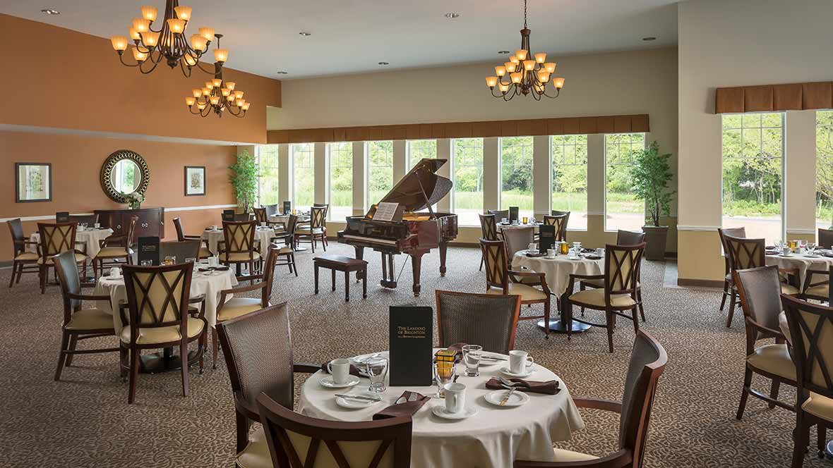 Elegant dining room with a grand piano and large windows.