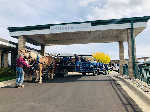 A horse-drawn wagon arrives at a community center, showcasing traditional transportation methods.