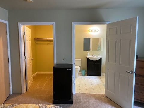 A cozy bedroom featuring a closet and an adjoining bathroom.