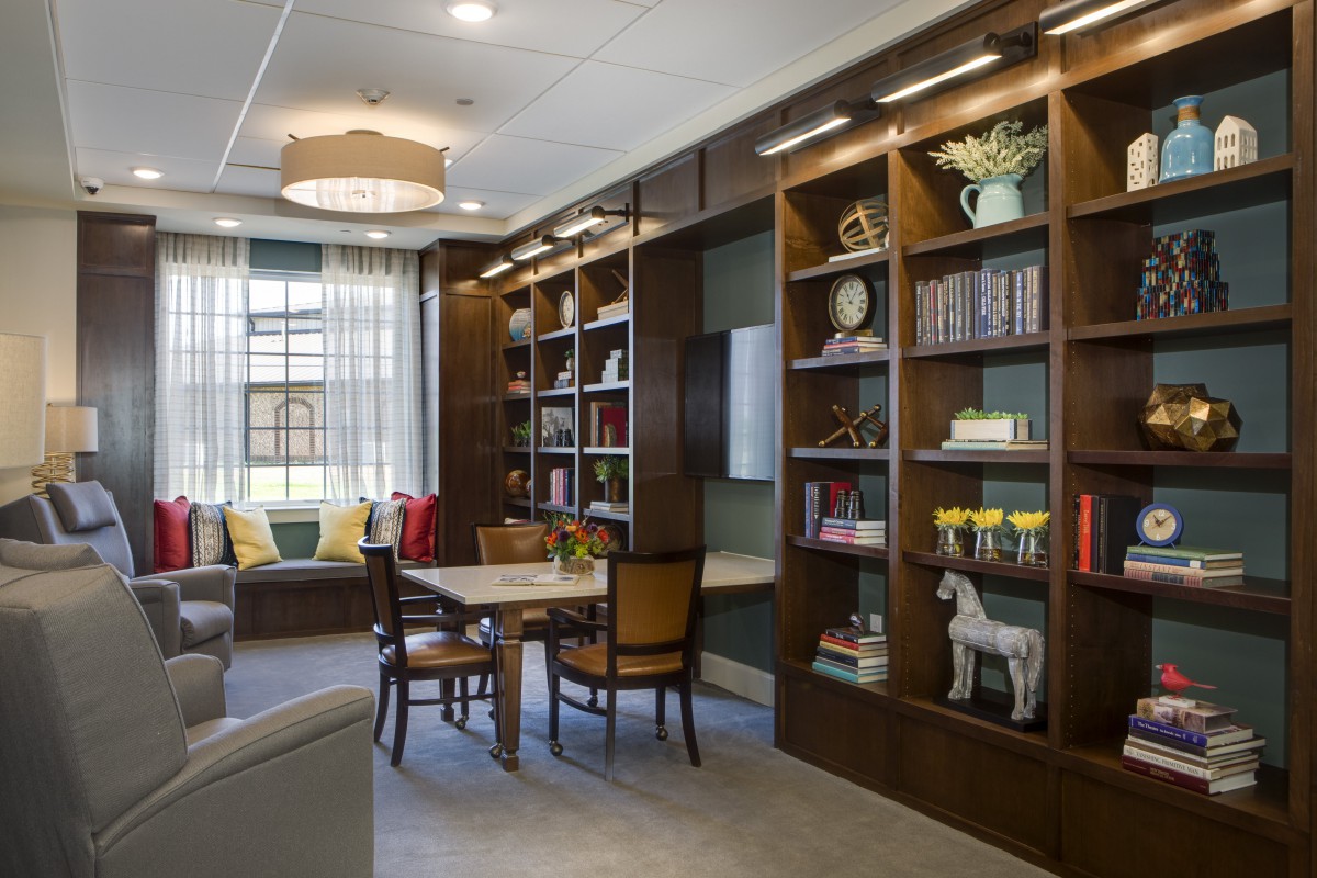A cozy reading area with bookshelves, a table, and chairs in a well-designed interior space.