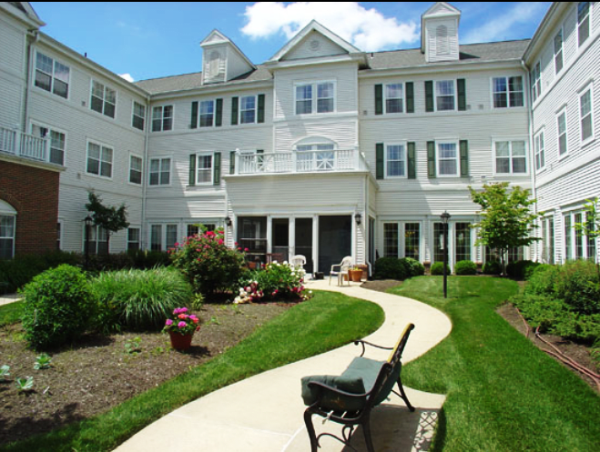 A view of a residential building with a well-maintained garden and pathway.