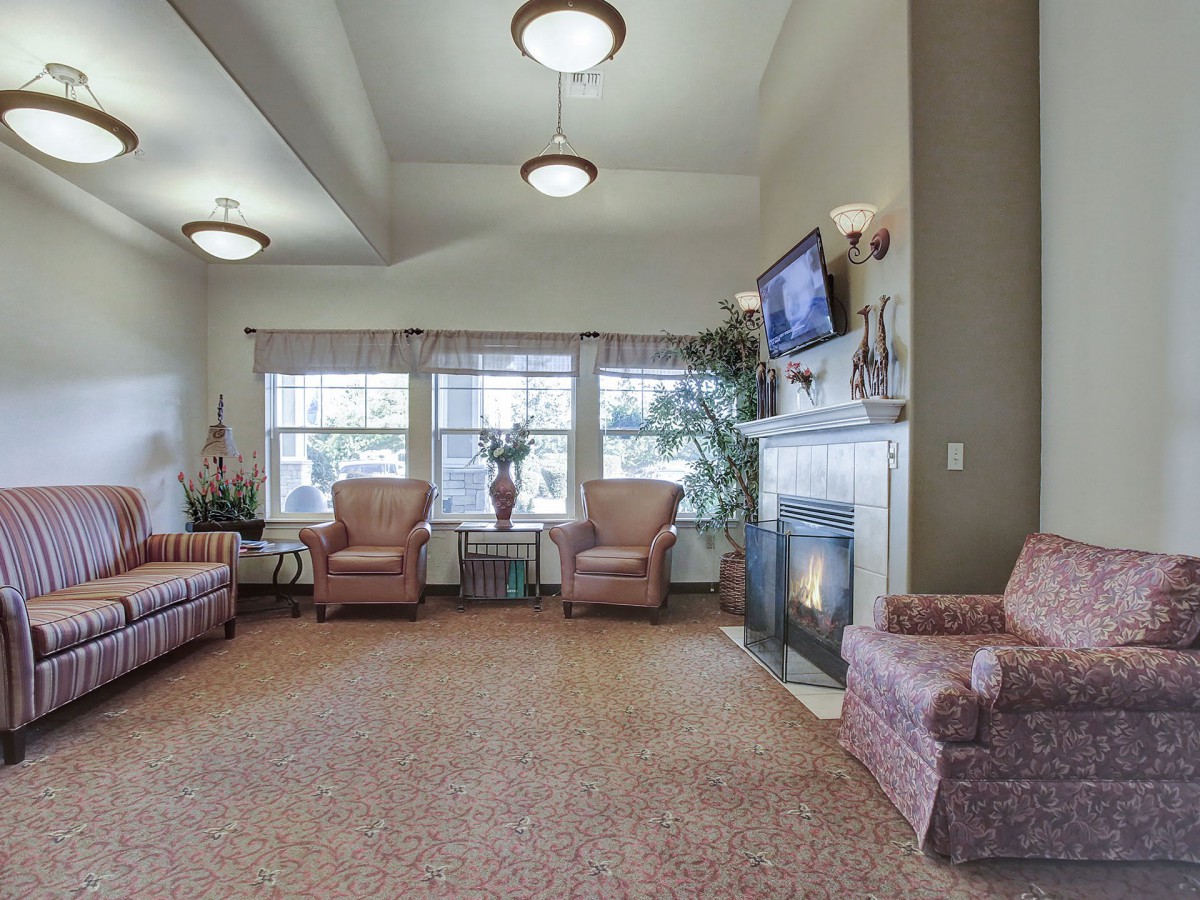 A cozy living room with comfortable seating, a fireplace, and a TV.