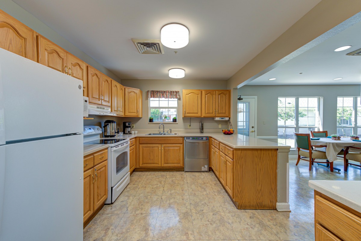 A spacious and bright kitchen with wooden cabinets and modern appliances.