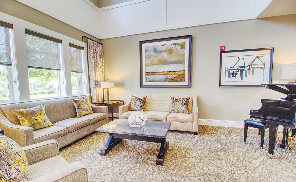 A cozy and elegantly designed living room featuring comfortable sofas, a stylish coffee table, and framed artwork on the wall.