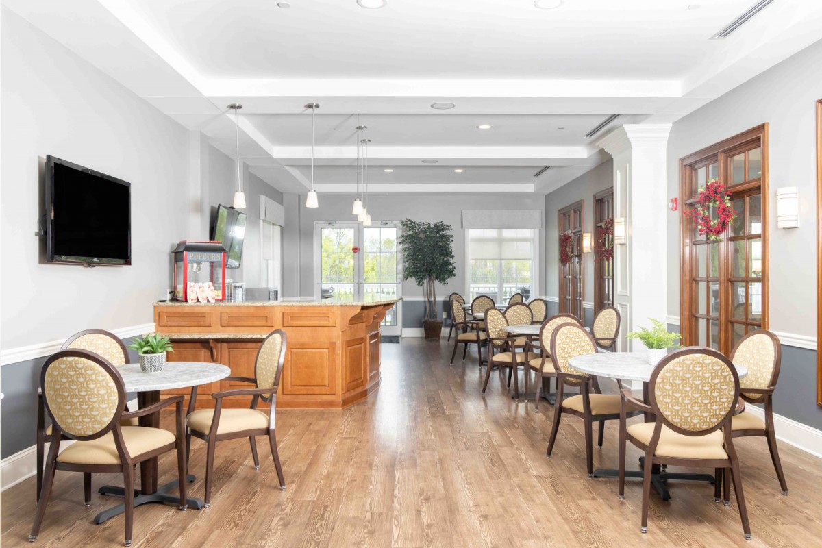 A modern restaurant interior with a bar and neatly arranged tables and chairs.