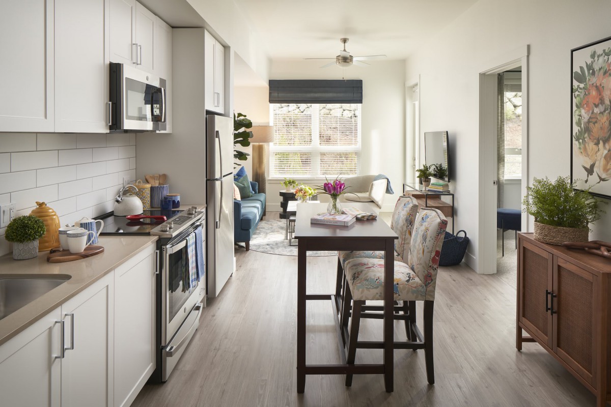 A modern, open-concept kitchen and dining area in an apartment.