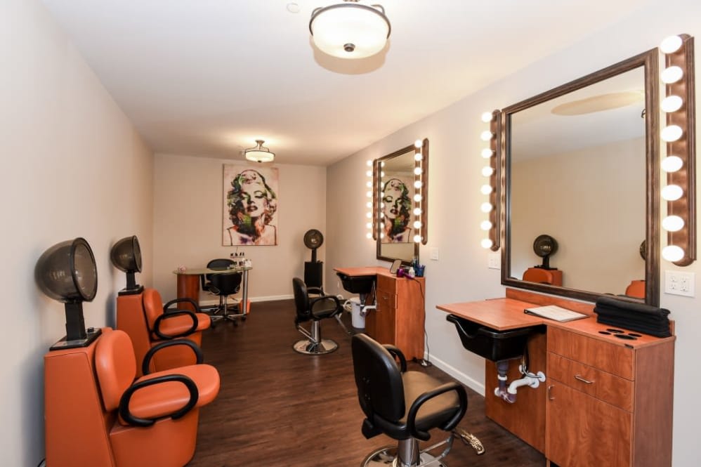 A well-lit beauty salon interior with styling chairs and mirrors.