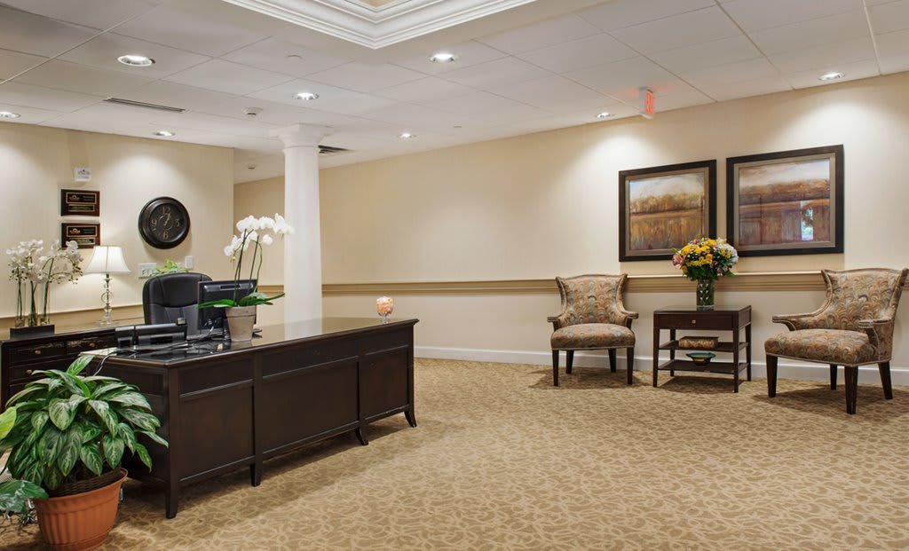 A warmly lit reception area with a wooden desk and comfortable seating.