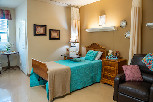 A cozy and well-decorated bedroom featuring a comfortable bed with colorful bedding, complemented by tasteful wall art and furniture.