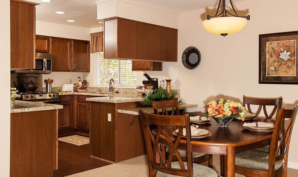 A cozy kitchen and dining area with wooden cabinets and a charming table setup.
