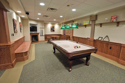 A spacious and inviting game room featuring a classic pool table and comfortable seating.