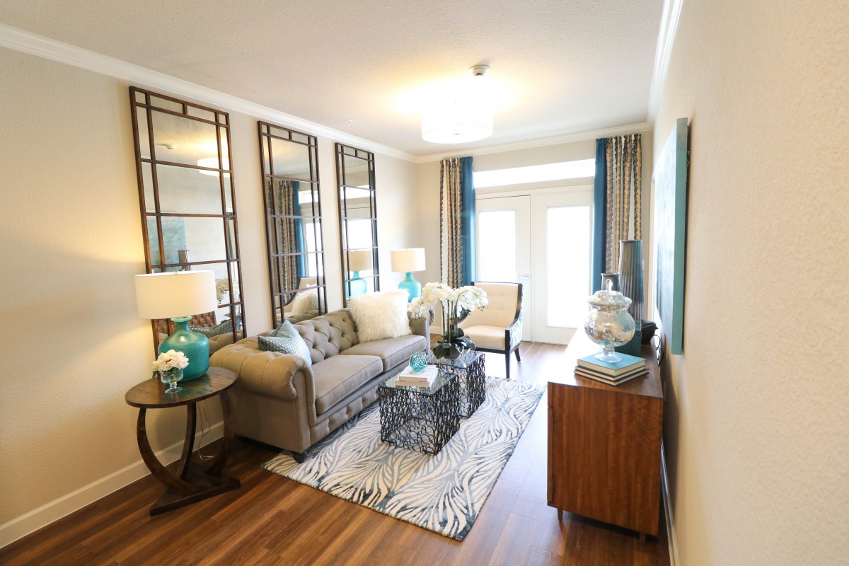 A modern living room with a comfortable sofa, decorative mirrors, and stylish accents.