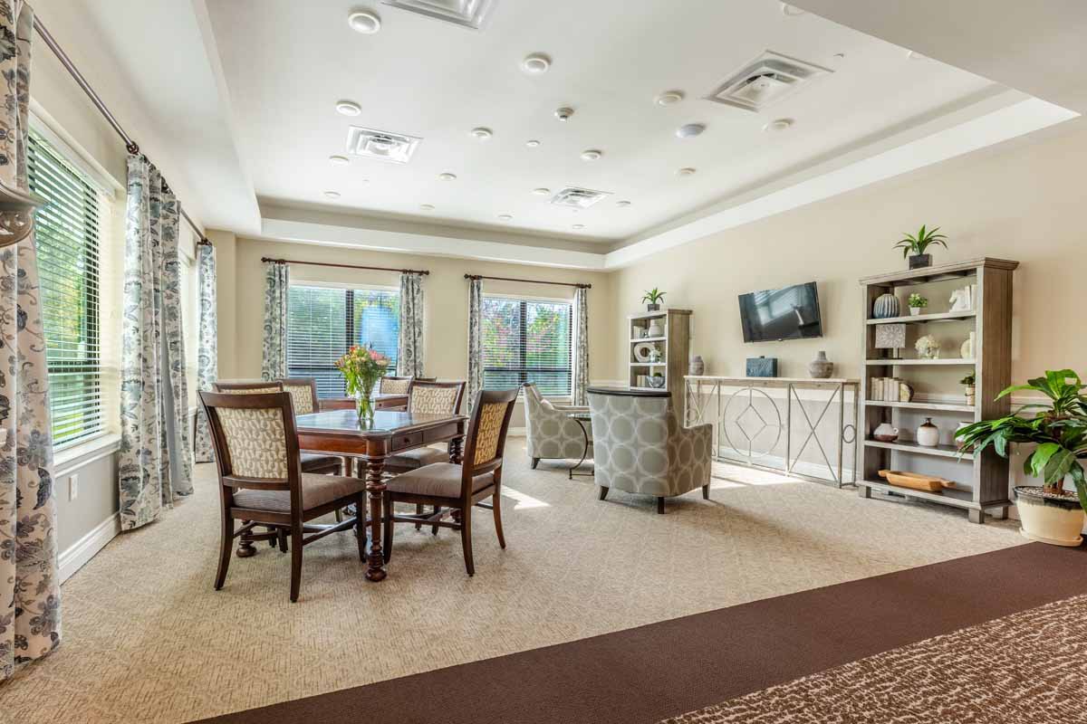 A spacious living room with a dining area, featuring neutral-toned furniture and ample natural light.