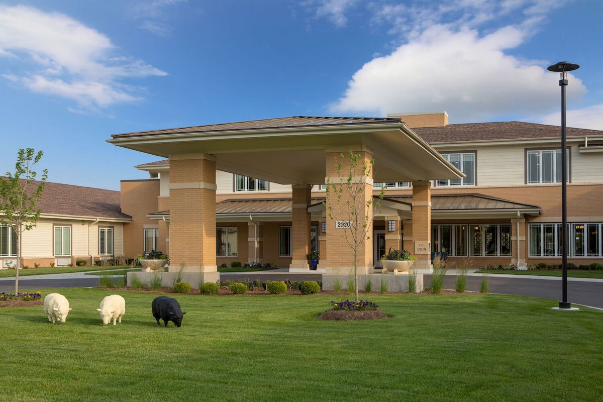 A modern building with a landscaped lawn under a clear blue sky.