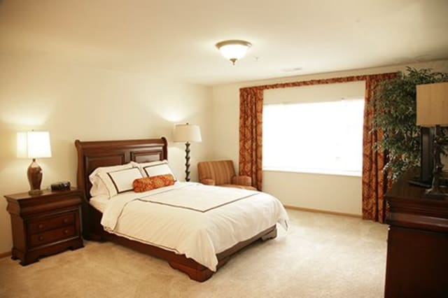 A cozy bedroom with classic wooden furniture and warm lighting.
