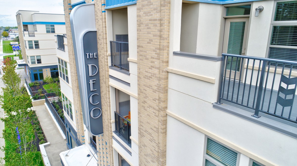 The exterior of The Deco, featuring modern architecture with balconies and signage.