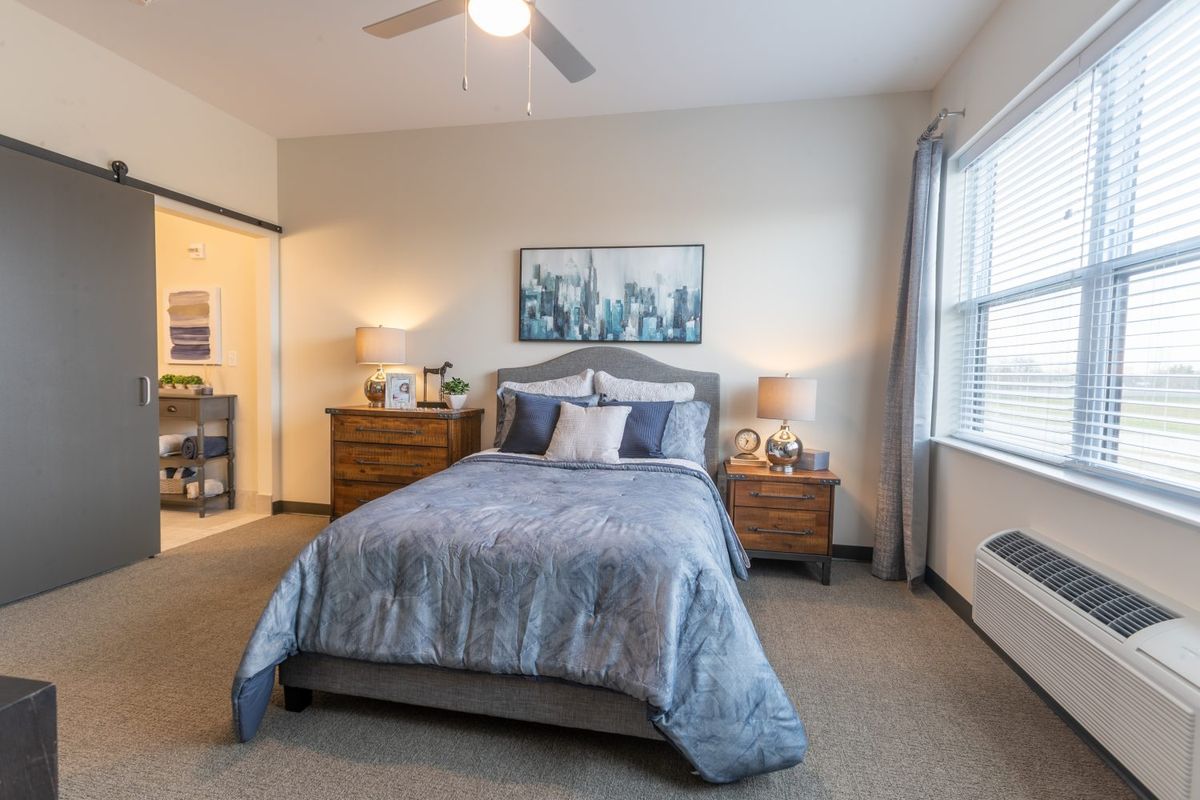 A cozy and well-decorated bedroom with a neatly made bed, nightstands, and framed artwork on the wall.