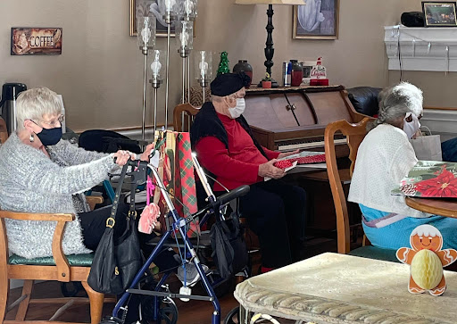 A serene moment indoors with elderly individuals enjoying each other's company.
