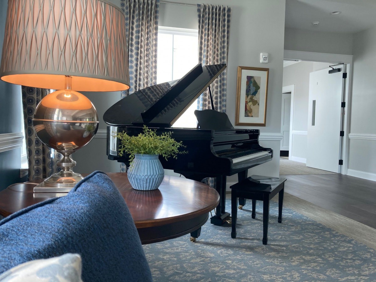 A stylish living room featuring a grand piano, modern decor, and elegant furnishings.
