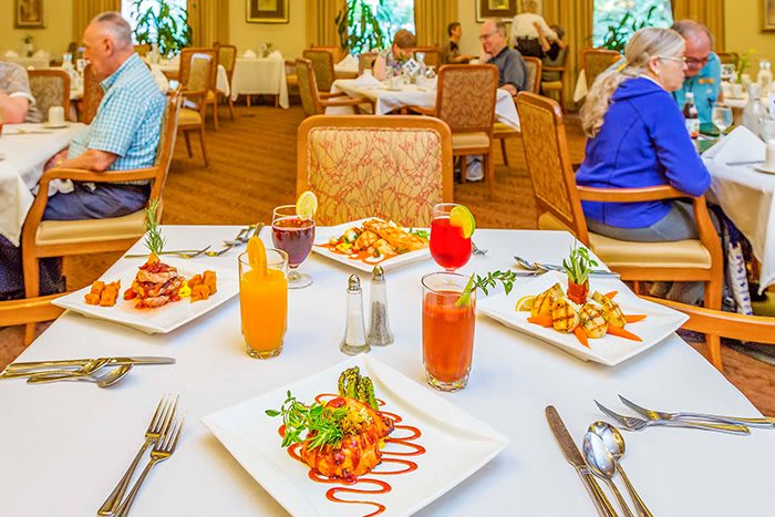 A beautifully set table with an array of dishes and drinks in a restaurant setting.