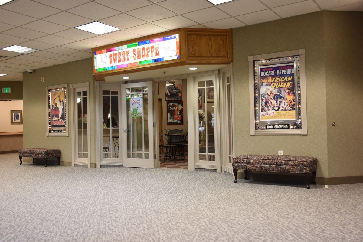Entrance to a movie theater lobby with colorful signs and posters on display.