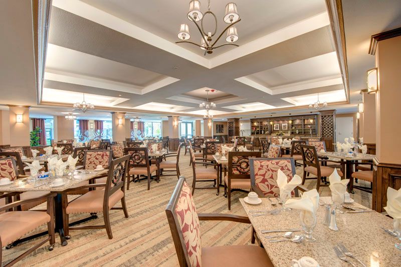 An elegant restaurant dining area with neatly arranged tables and chairs under soft lighting.