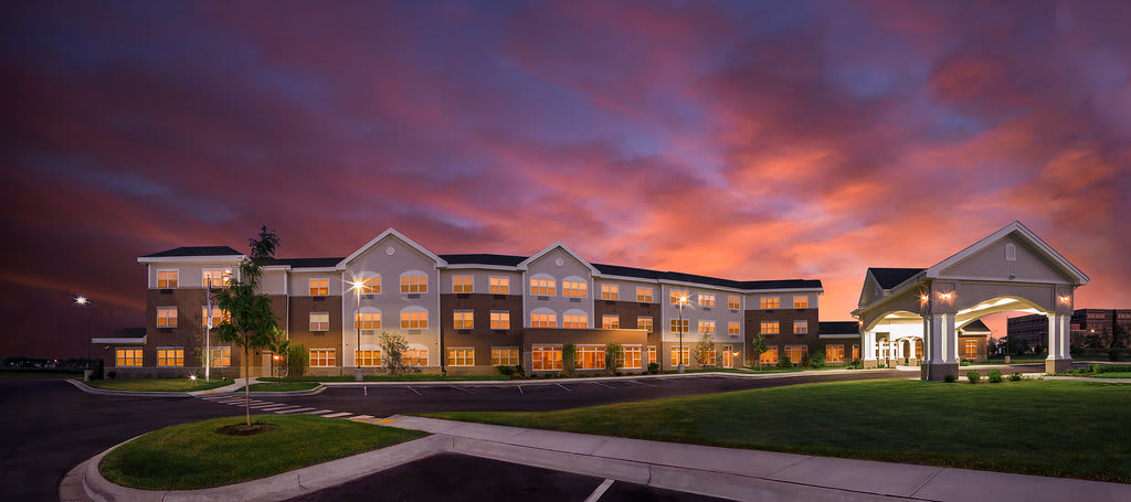 A residential building at dusk with a vibrant sunset sky.